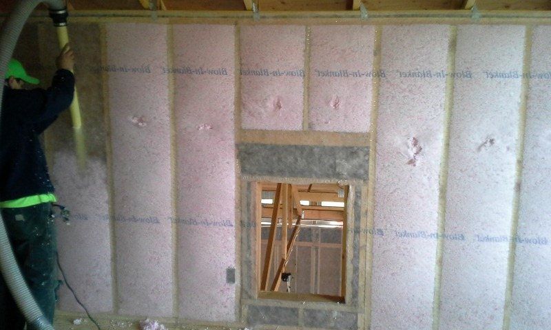 Falls Insulation technician installing wall insulation